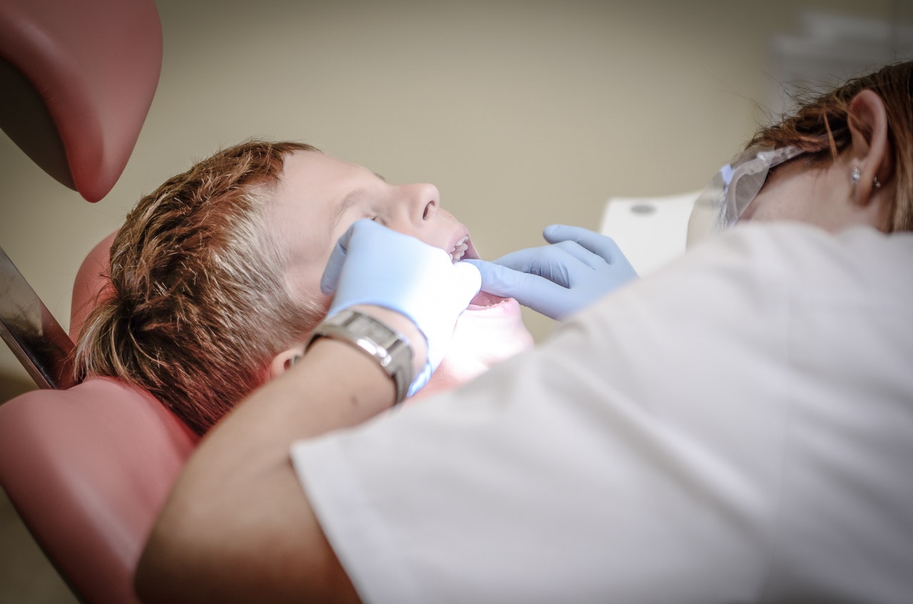 Dental hygienist cleaning child's teeth 